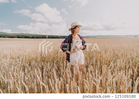 Woman in a Wheat Field with a Tablet 125109180