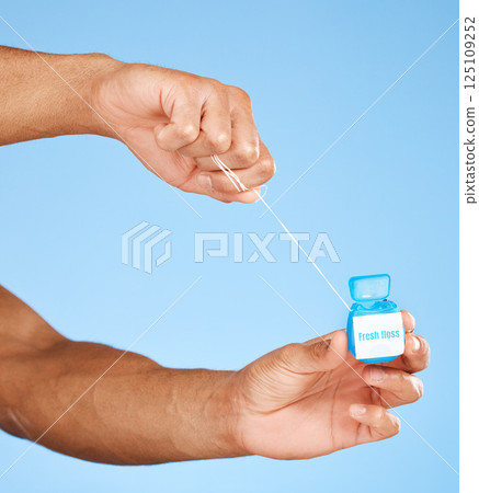 Floss, dental healthcare and man hands with product container on studio mock up for teeth, mouth and dentist cleaning marketing. Medical, wellness and dental floss health care with blue mockup 125109252