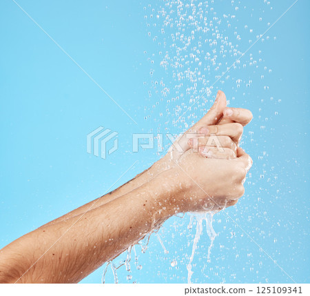 Woman, water splash or washing hands on blue background in studio for hygiene maintenance, bacteria security safety or grooming. Zoom, model or wet cleaning in shower skincare wellness and healthcare 125109341