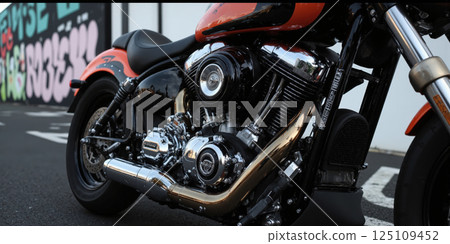A close-up shot of a custom motorcycle, its engine gleaming under the spotlight, with intricate detailing on the bodywork and a backdrop 125109452
