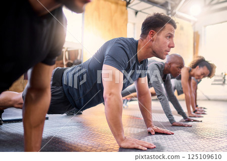 Wellness, team and push ups in gym, workout and fitness for focus, training together and health. Group, diversity or athletic people in sportswear being healthy, strong or with endurance for exercise 125109610