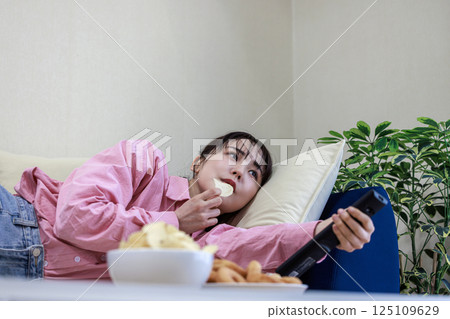 吃甜點的婦女，當看電視時 125109629