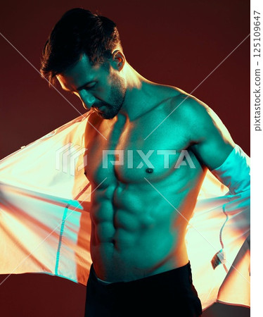 Man, tattoo and shirtless body in studio with fitness, health and beauty with light, glow and sexy. Model, six pack and body art ink for healthy skin, cosmetics and fashion while trendy, edgy or hot 125109647