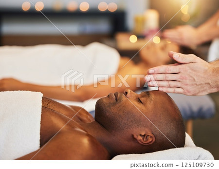 Hands, massage and relax with a black man customer in a spa for physical therapy or rest in a resort. Luxury, wellness and zen with a male client lying on a bed for stress relief at a lodge Hands, massage and relax with a black man customer in a spa for physical therapy or rest in a resort. Luxury, wellness and zen with a male client lying on a bed for stress relief at a lodge 125109730