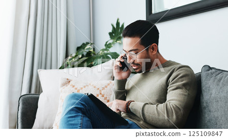 Phone call, tablet and man on sofa in home for client feedback with freelance job. Cellphone, networking and person with digital technology in living room for mobile discussion with online review. Phone call, tablet and man on sofa in home for client feedback with freelance job. Cellphone, networking and person with digital technology in living room for mobile discussion with online review. 125109847