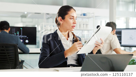 Woman, documents and laptop at office for finance, results or report for trading on stock market. Person, paperwork and reading with perspective for accounting, revenue or profit at investment agency 125110137