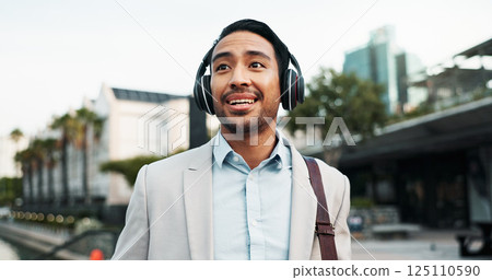 Business, man and walking with headphones in city for morning commute, music playlist and streaming audio. Professional, person and smile outdoor for sound track, corporate podcast and work travel 125110590