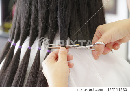 A woman cutting hair for hair donation A woman cutting hair for hair donation 125111280