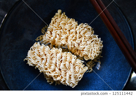 Uncooked instant noodles in a bowl. Uncooked instant noodles in a bowl. 125111442