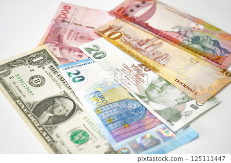 One dollar, 20 euro, 20 Turkish lira, 10 euro, 100 thai baht and 1 bahraini dinar on the table. 125111447