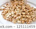 Salted peanuts on a white plate. Healthy and dietary food. 125111459