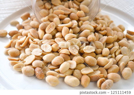 Salted peanuts on a white plate. Healthy and dietary food. 125111459