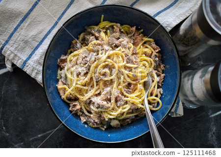 Spathetti sardine with fork in a bowl. Pasta sardines on fork. Traditional healthy Italian food. 125111468