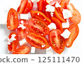 Cherry plum tomatoes slices with feta cheese on a white plate. Healthy and dietary eating concept. 125111470