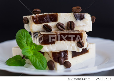 delicate milky coffee jelly in a plate with a sprig of mint 125112387
