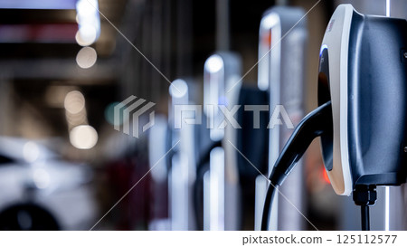 EV charging station and electric car, Electric car charging station for charge EV battery, Plug for vehicle with electric engine, EV charger clean energy, Charging point at car parking lot. 125112577