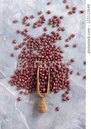 Scoop full of dried azuki beans on gray top view. East Asian legumes, vegetarian protein source 125112648