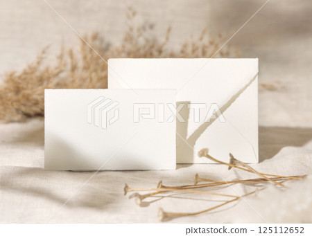 Card and envelope near dry beige pampas grass on linen closeup, mockup. Bohemian wedding stationery 125112652