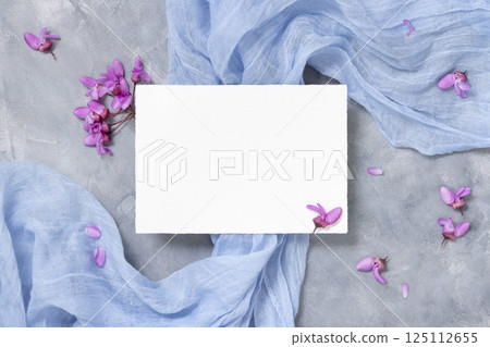 Blank card on fabric near wild purple flowers top view on gray, spring wedding mockup Blank card on fabric near wild purple flowers top view on gray, spring wedding mockup 125112655