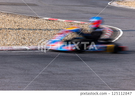 Motion blur kart driver drive go kart on kart race track circuit, Go kart racer driver on curve race track, Extreme sport 125112847