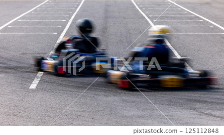 Motion blur kart driver drive go kart on kart race track circuit, Go kart racer driver on curve race track, Extreme sport 125112848