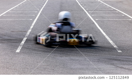 Motion blur kart driver drive go kart on kart race track circuit, Go kart racer driver on curve race track, Extreme sport 125112849