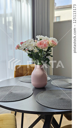 Pink vase with flowers highlights refined dining space, flowers reflecting gentle pastel palette, flowers elevating modern interior vibe, appealing to brand imagery and editorial concepts Pink vase with flowers highlights refined dining space, flowers reflecting gentle pastel palette, flowers elevating modern interior vibe, appealing to brand imagery and editorial concepts 125113173