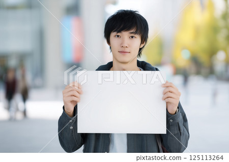 Male student holding a message board (AI-generated image) 125113264