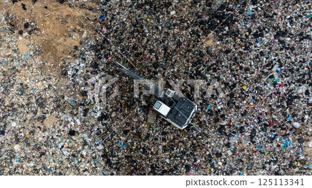 Garbage dump pile in trash dump or landfill, Landfill with waste disposal, Garbage truck unloads rubbish in landfill, Truck waste dump waste from household, Excavator work garbage waste, Aerial view. 125113341