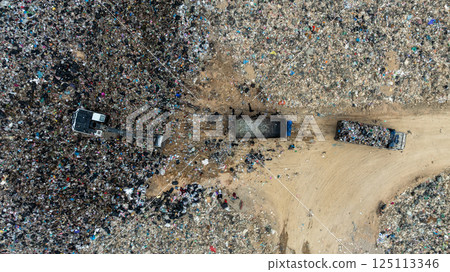 Garbage dump pile in trash dump or landfill, Landfill with waste disposal, Garbage truck unloads rubbish in landfill, Truck waste dump waste from household, Excavator work garbage waste, Aerial view. 125113346
