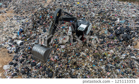 Garbage dump pile in trash dump or landfill, Landfill with waste disposal, Garbage truck unloads rubbish in landfill, Truck waste dump waste from household, Excavator work garbage waste, Aerial view. 125113355
