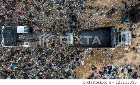 Garbage dump pile in trash dump or landfill, Landfill with waste disposal, Garbage truck unloads rubbish in landfill, Truck waste dump waste from household, Excavator work garbage waste, Aerial view. Garbage dump pile in trash dump or landfill, Landfill with waste disposal, Garbage truck unloads rubbish in landfill, Truck waste dump waste from household, Excavator work garbage waste, Aerial view. 125113356