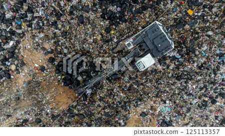 Garbage dump pile in trash dump or landfill, Landfill with waste disposal, Garbage truck unloads rubbish in landfill, Truck waste dump waste from household, Excavator work garbage waste, Aerial view. 125113357