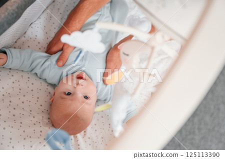 Top view of newborn baby that is lying down in the cradle Top view of newborn baby that is lying down in the cradle 125113390