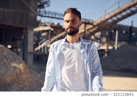 Man in uniform is working in the quarry at daytime Man in uniform is working in the quarry at daytime 125113641