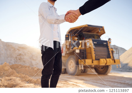 Quarry worker making a deal with colleague. Shaking hands Quarry worker making a deal with colleague. Shaking hands 125113897