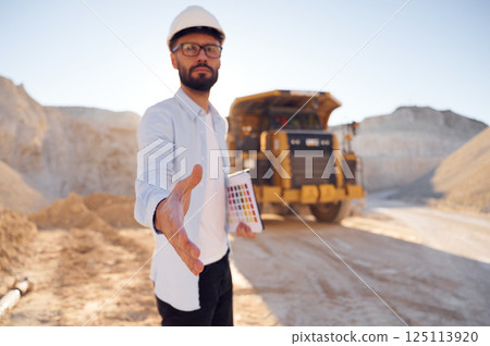 Giving the hand. Man in uniform is working in the quarry at daytime 125113920