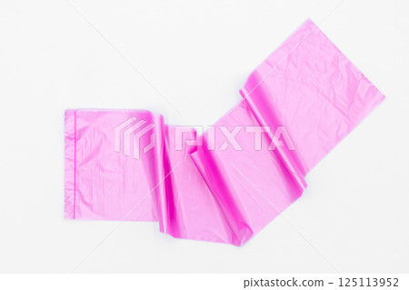 Roll of pink plastic garbage bags on white background, Pink color garbage bags roll,  Roll of pink plastic garbage bags on white background. 125113952