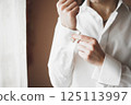 Grooms morning preparation. Handsome man getting dressed and preparing for the wedding 125113997