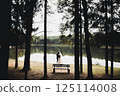 Newly married couple running and jumping in park while holding hands 125114008