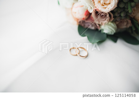 Two golden wedding rings isolated background concept Two golden wedding rings isolated background concept 125114058
