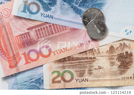 Many of different Chinese yuan banknotes. Chinese paper currency Yuan renminbi banknotes and coins as background. Many of different Chinese yuan banknotes. Chinese paper currency Yuan renminbi banknotes and coins as background. 125114219