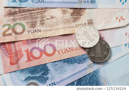 Many of different Chinese yuan banknotes. Chinese paper currency Yuan renminbi banknotes and coins as background. Many of different Chinese yuan banknotes. Chinese paper currency Yuan renminbi banknotes and coins as background. 125114224
