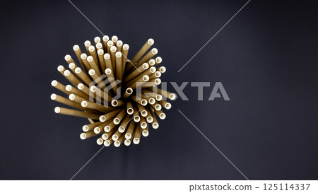 Paper straws on black background, Paper straws, Accessories for drinking outdoors, Ecology recycling eco friendly, Eco friendly reusable paper straws, Kraft paper straw for drinking coffee or tea. Paper straws on black background, Paper straws, Accessories for drinking outdoors, Ecology recycling eco friendly, Eco friendly reusable paper straws, Kraft paper straw for drinking coffee or tea. 125114337
