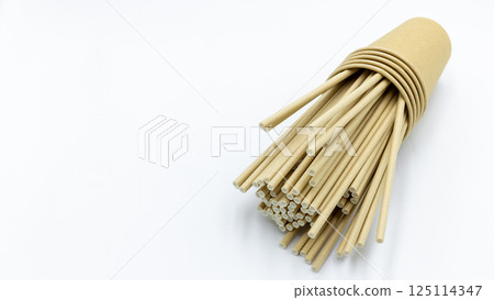 Paper cups and paper straws on white background, Accessories for drinking outdoors, Ecology recycling eco friendly, Eco friendly reusable paper straws, Kraft paper straw for drinking coffee or tea. Paper cups and paper straws on white background, Accessories for drinking outdoors, Ecology recycling eco friendly, Eco friendly reusable paper straws, Kraft paper straw for drinking coffee or tea. 125114347