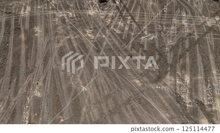 Tyre track on dirt sand or mud off road track, Tire mark ground vehicle wheel shape, Dirt soil texture, Top view tires tracks on dry mud background and texture. 125114477