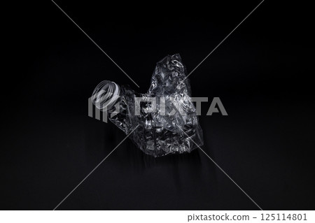 Crushed plastic water bottle on black background, Save the environment, Twisted plastic water bottle on black background. 125114801
