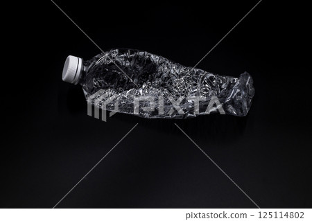 Crushed plastic water bottle on black background, Save the environment, Twisted plastic water bottle on black background. Crushed plastic water bottle on black background, Save the environment, Twisted plastic water bottle on black background. 125114802
