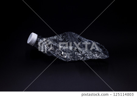 Crushed plastic water bottle on black background, Save the environment, Twisted plastic water bottle on black background. 125114803