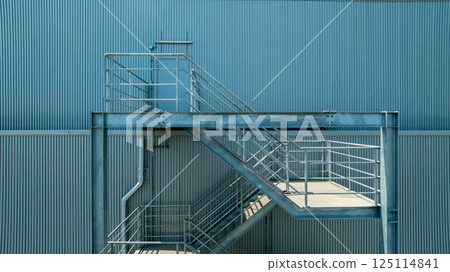 Fire Escape stairs on the building wall in factory building, Industrial elements and fire escape stairs, Metal outdoor industrial stairs ire escape stairs. Fire Escape stairs on the building wall in factory building, Industrial elements and fire escape stairs, Metal outdoor industrial stairs ire escape stairs. 125114841